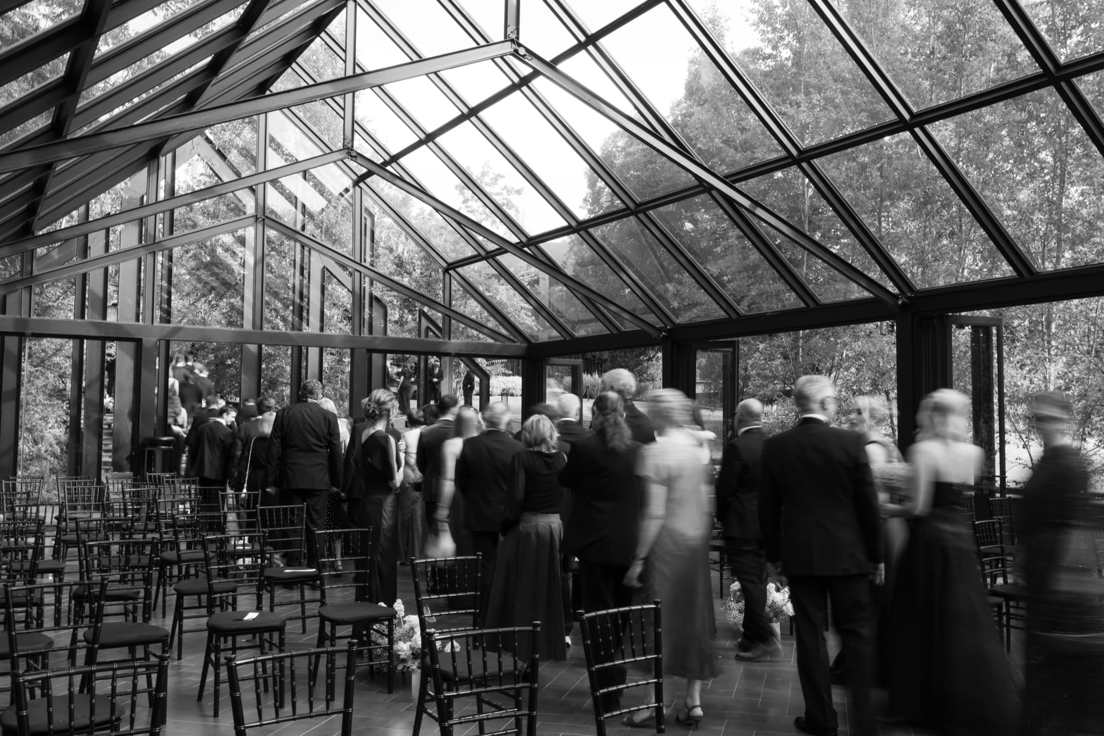 Wedding guests gathering in the glass chapel at Inimitable